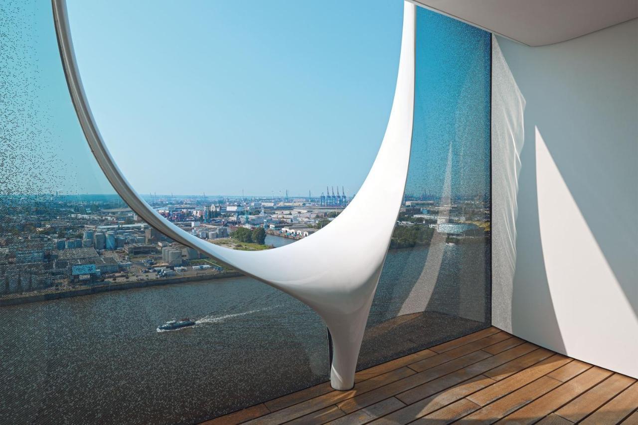 The Westin Hamburg Elbphilharmonie Hotell Eksteriør bilde The photo showcases a modern architectural interior featuring a large, uniquely designed window that creates a dramatic visual effect. The window has an organic, flowing shape, resembling a sculptural element, and is made of glass that allows natural