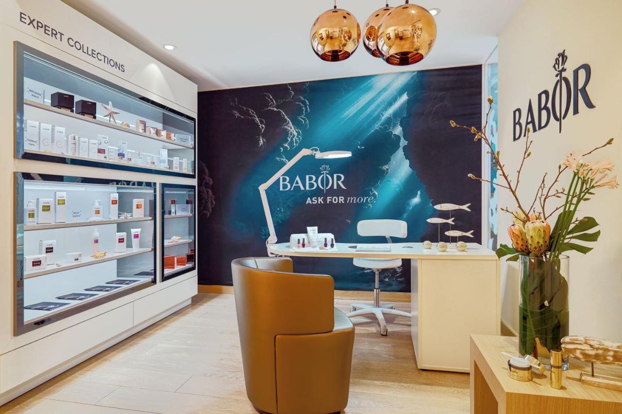 The Westin Hamburg Elbphilharmonie Hotell Eksteriør bilde The image shows an interior shot of a beauty salon or spa that features products from the brand Babor. The space includes a stylish brown chair, a modern white desk, and a decorative display of skincare products on shelves. There is also a prominent 